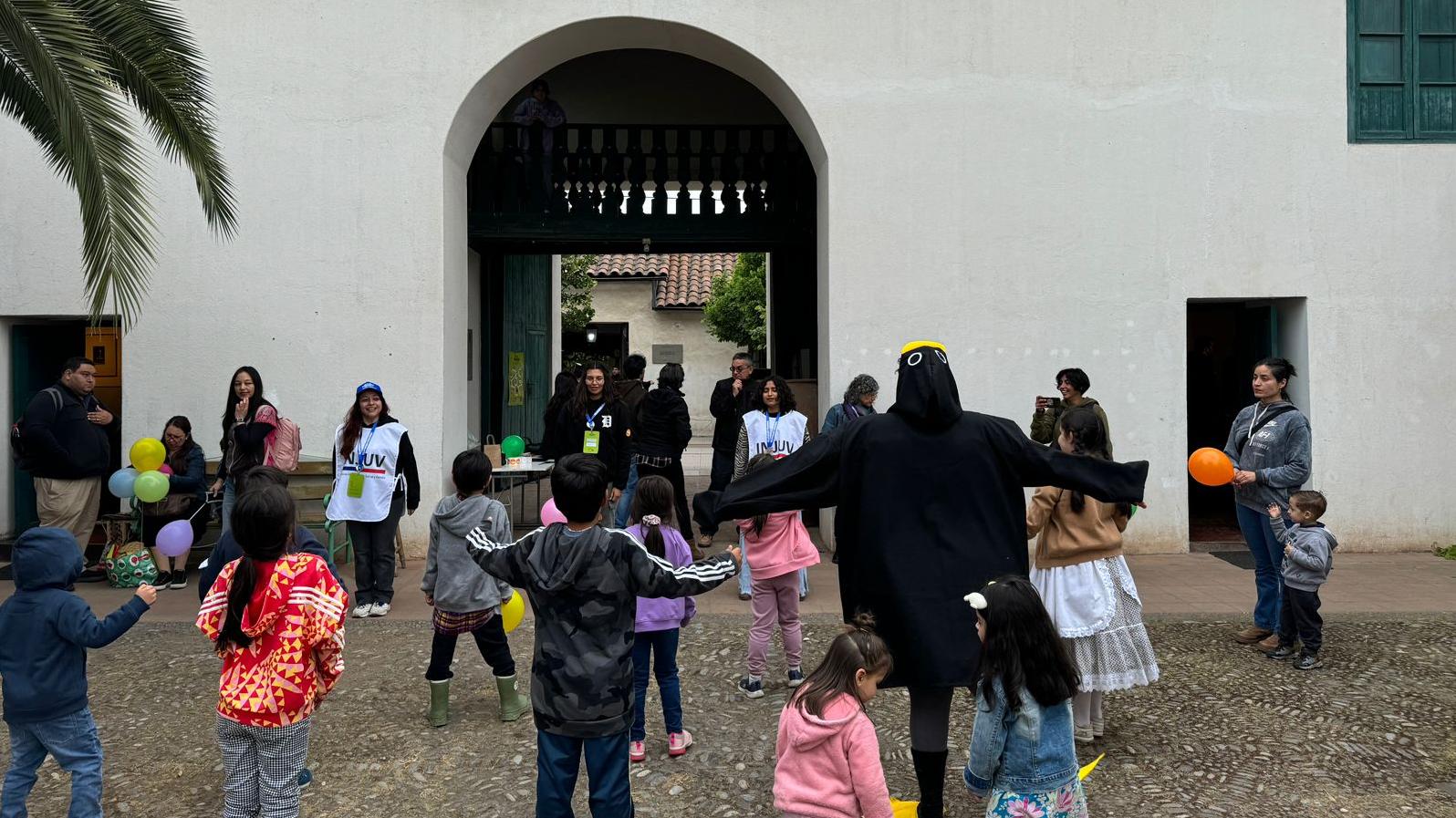 Niñas y niños de pie en un patio empedrado