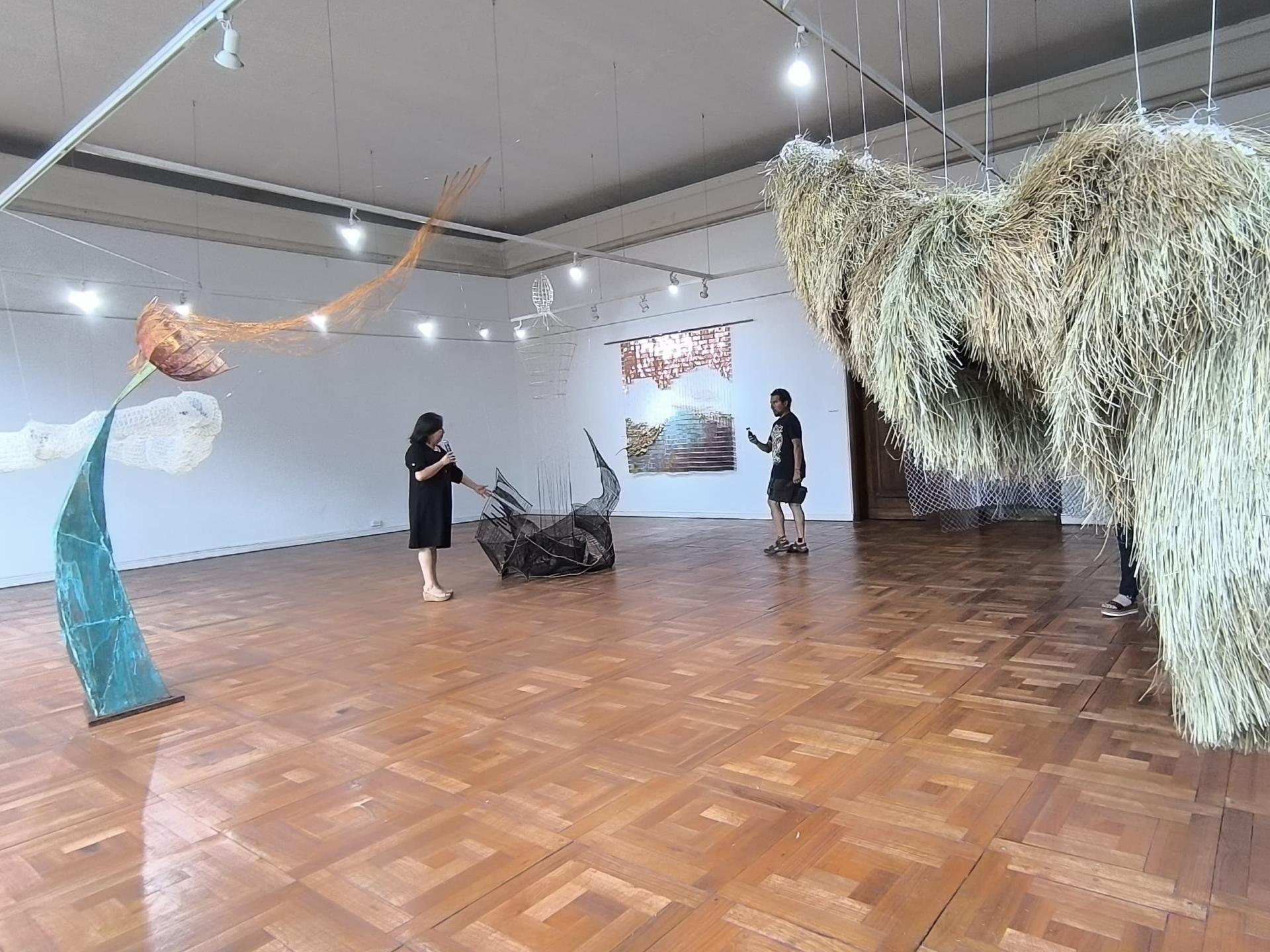 salon con piso de madera con objetos de gran volumen colgando desde el techo