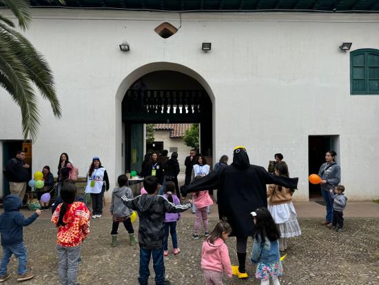 Niñas y niños de pie en un patio empedrado